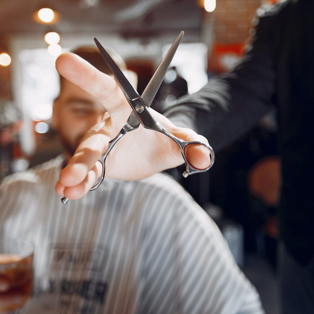 elegante-uomo-seduto-in-un-negozio-di-barbiere_1157-21725